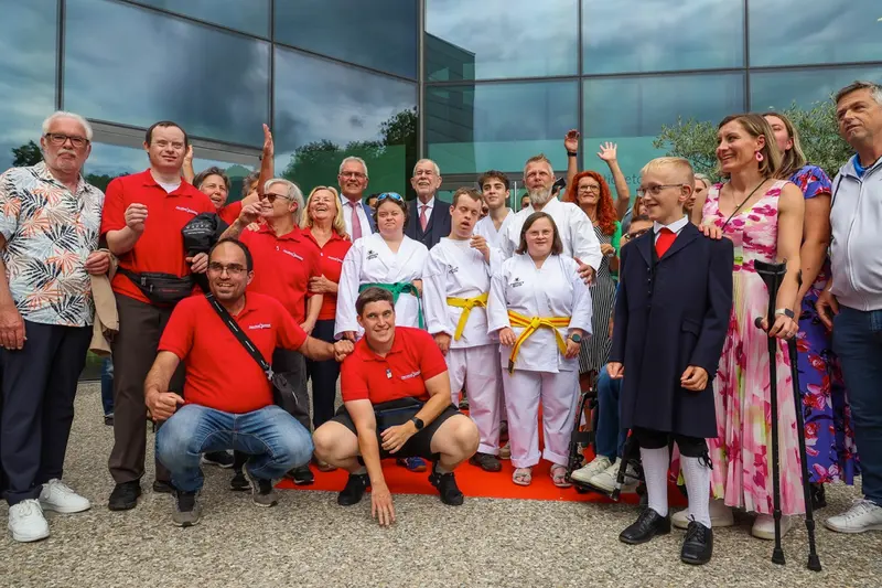 Gruppe in roten und weißen Oberteilen jubelt gemeinsam im Freien