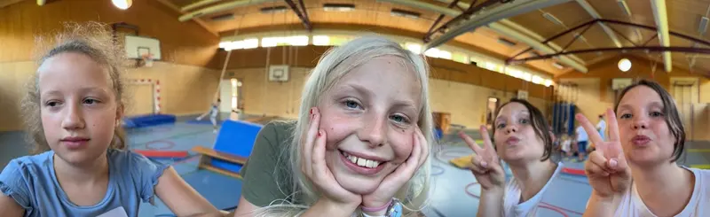 Kind lächelt breit mit den Händen am Gesicht