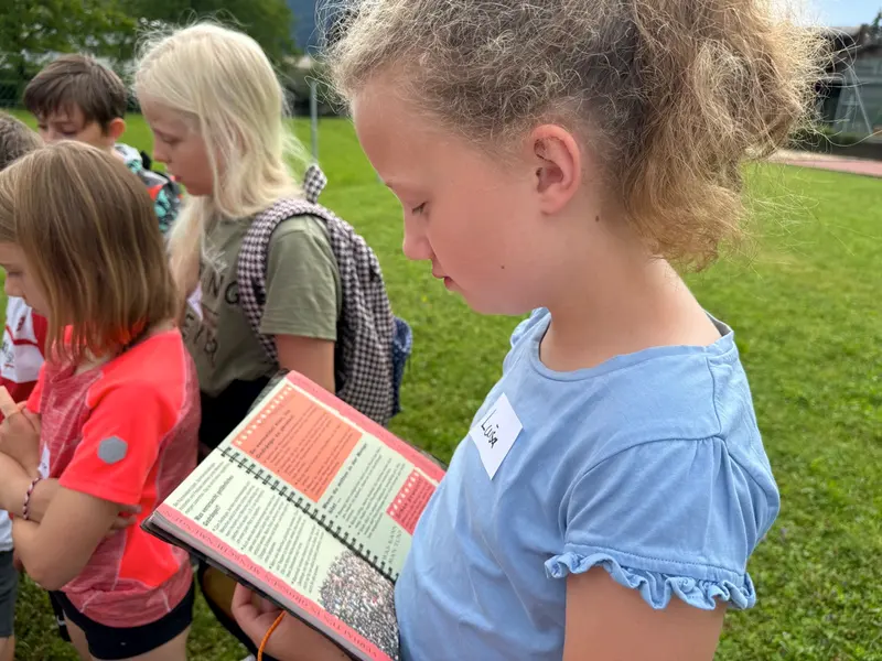 Zwei Kinder lesen gemeinsam in einem Heft