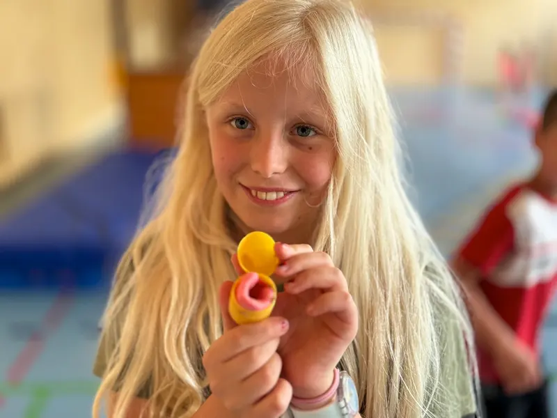 Kind lächelt und hält ein kleines Spielzeug in der Hand