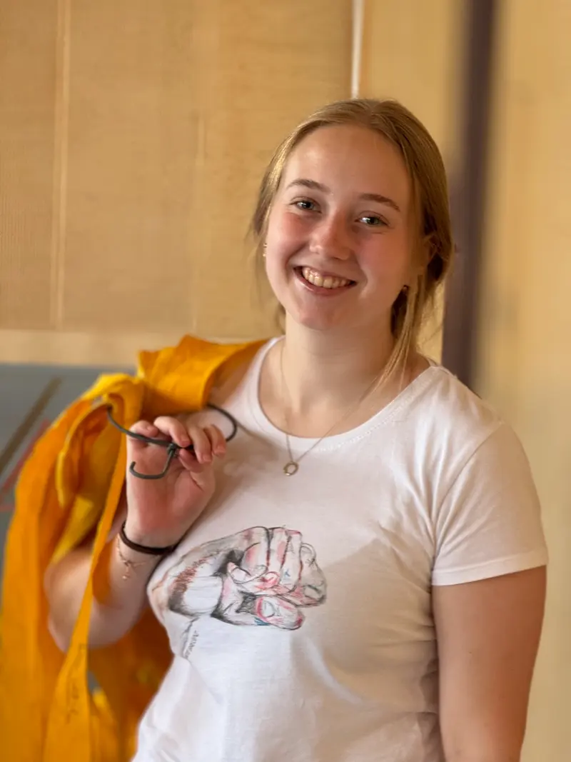 Kind lächelt mit einem gelben Tuch in der Hand