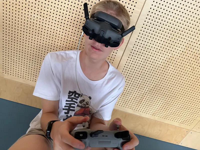 Kind trägt eine VR-Brille und hält einen Controller