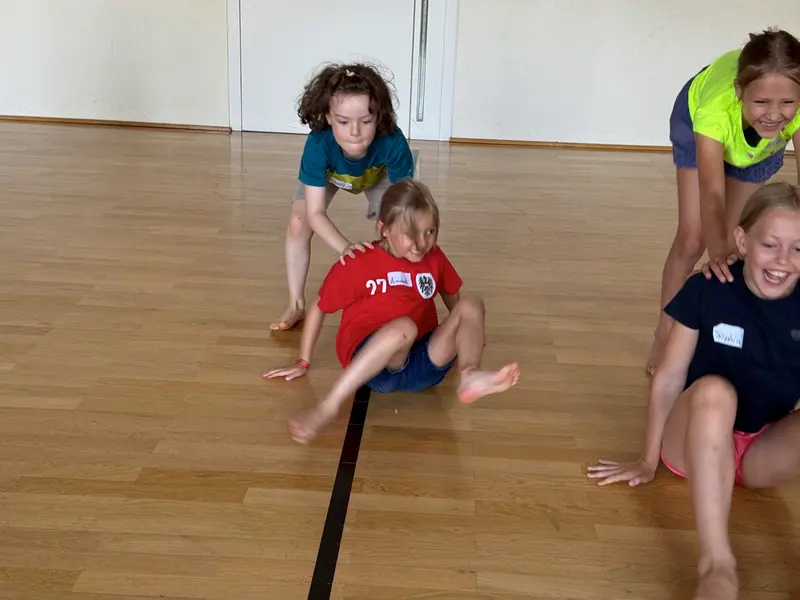 Zwei Kinder spielen ausgelassen auf dem Turnhallenboden