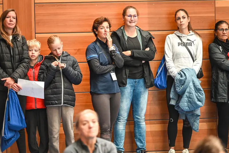 Gruppe steht beobachtend an der Hallenwand