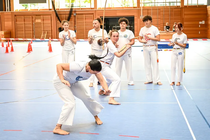 Zwei Personen in weißer Kleidung bei Capoeira-Vorführung
