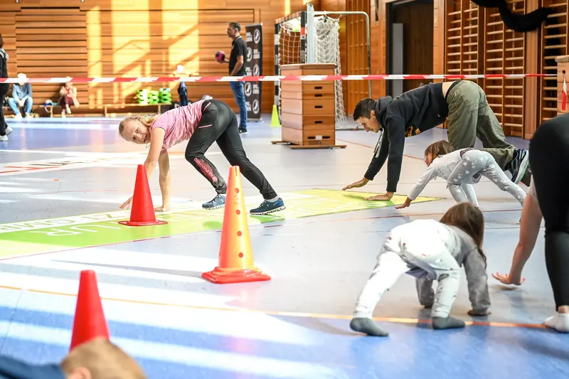 Kinder und Erwachsene krabbeln auf allen Vieren über Matte