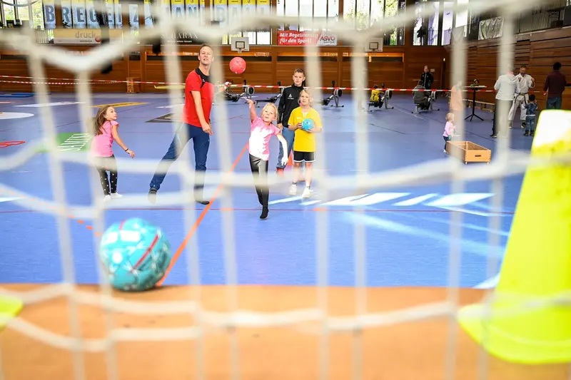Kinder spielen Torwandschießen in einer Sporthalle