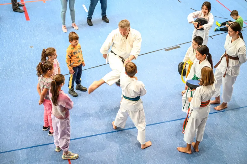 Trainer übt Karatetechnik mit Kindern in einer Reihe