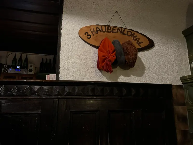 Verziertes Holzschild hängt an der Wand einer Gaststube