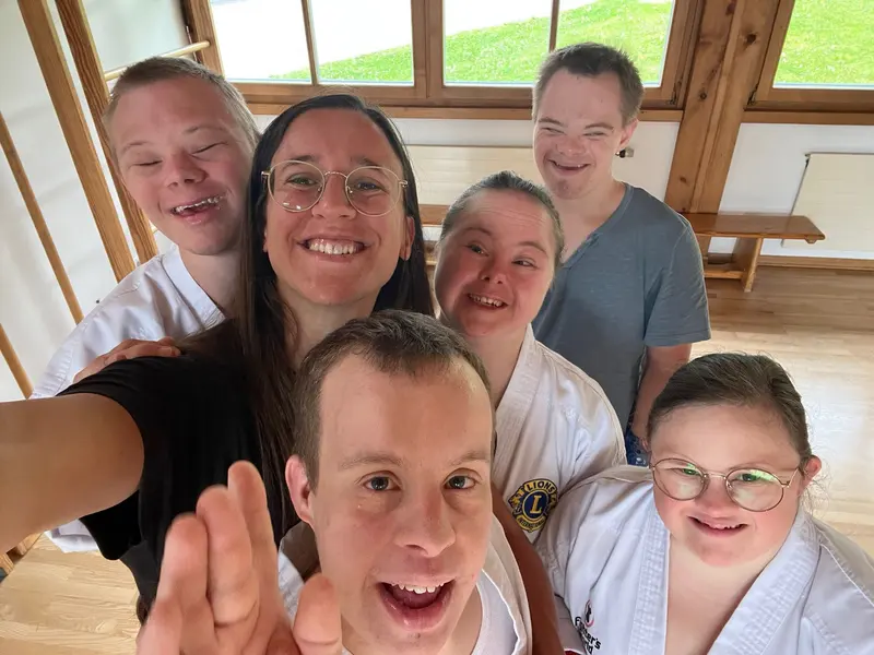 Fünf Personen posieren eng zusammen für Gruppen-Selfie