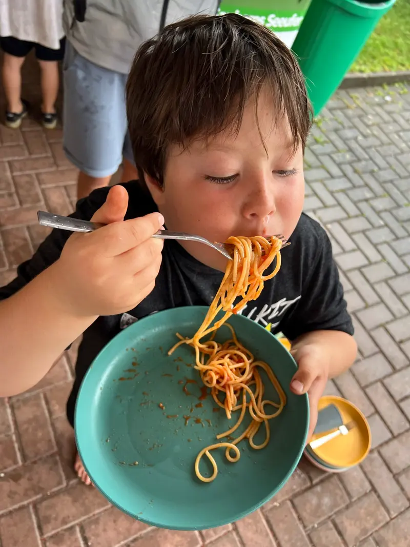 Kind isst mit der Gabel Spaghetti aus einer Schüssel
