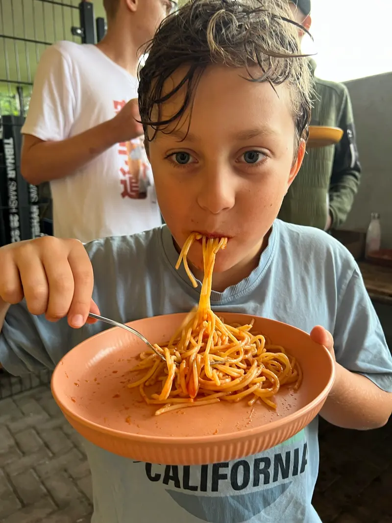 Kind isst genüsslich Spaghetti aus einer Schüssel