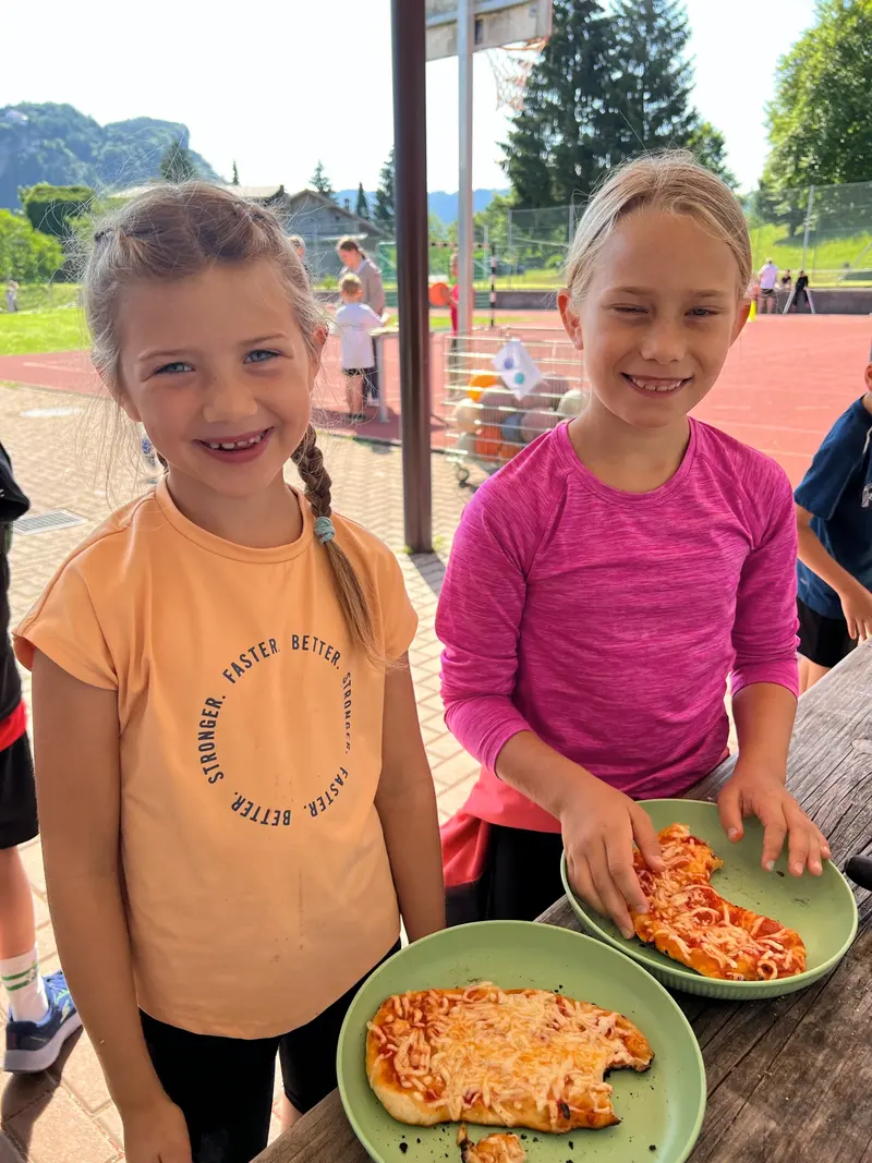 Zwei Kinder lächeln nebeneinander in der Turnhalle