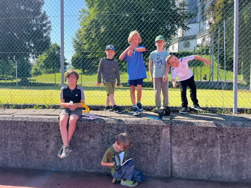 Gruppe von Kindern sitzt und steht auf einer Mauer im Freien