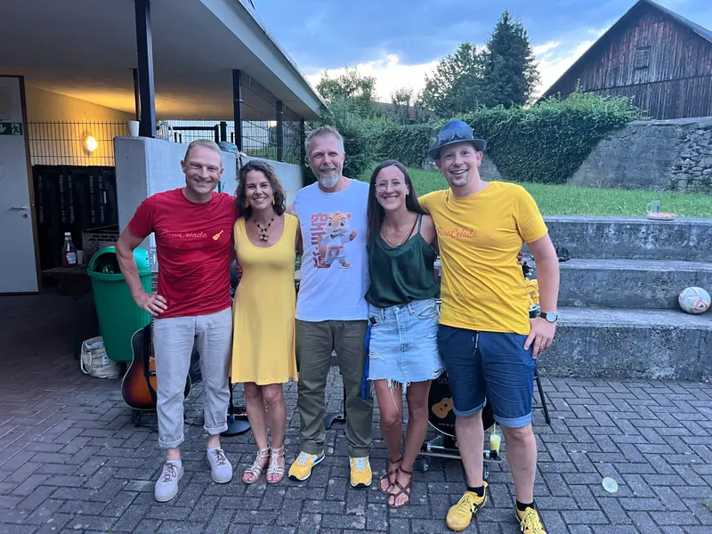 Fünf Personen stehen gemeinsam vor einem Gebäude.