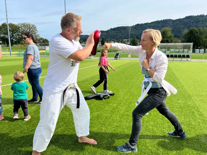 Zwei Personen trainieren mit Schlagpolstern im Freien