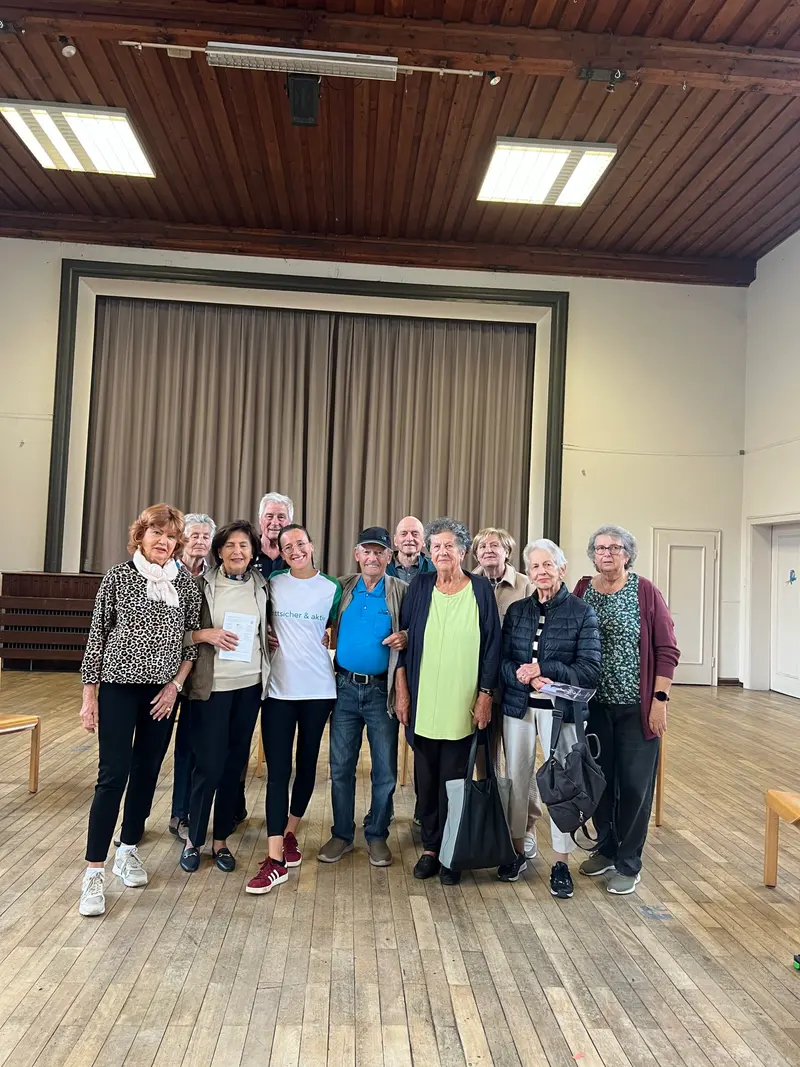 Gruppe posiert für ein Erinnerungsfoto in einem Saal