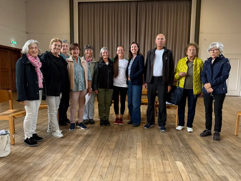 Gruppe steht gemeinsam für ein Abschlussfoto im Saal