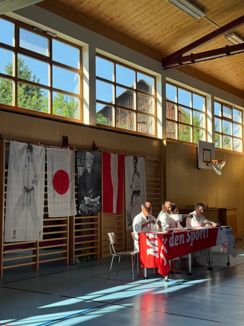 Sporthalle mit Flaggen und Prüfertisch, vorbereitet für die Gürtelprüfung