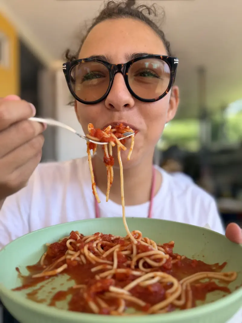 Betreuerin isst Spaghetti mit der Gabel