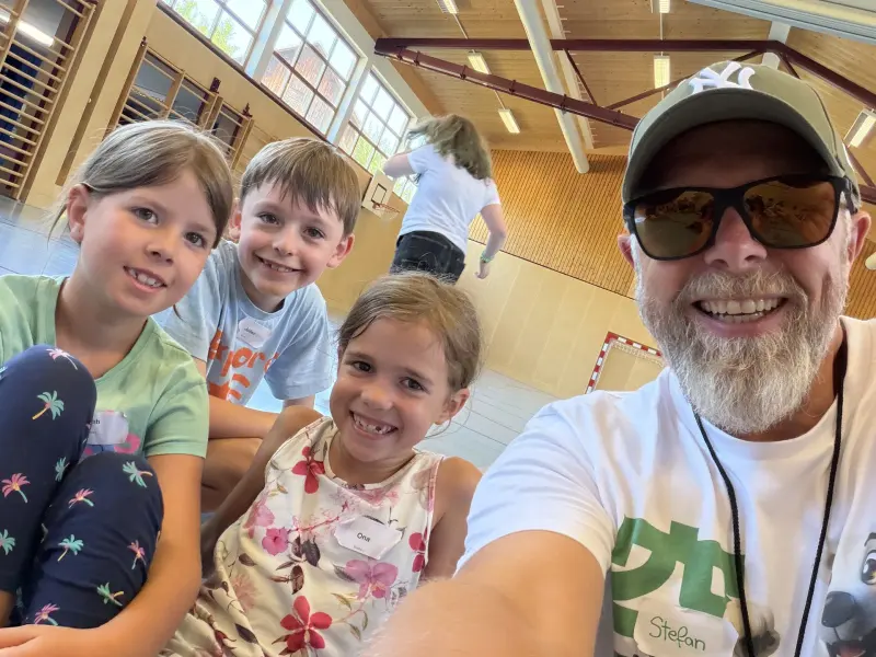 Betreuer macht Selfie mit drei Kindern in Halle