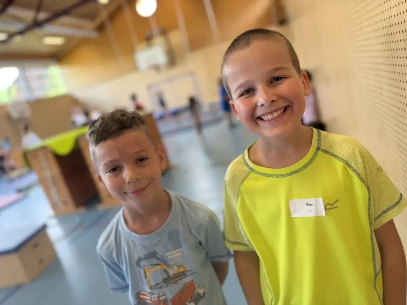 Zwei Kinder lächeln in der Halle vor Hindernissen