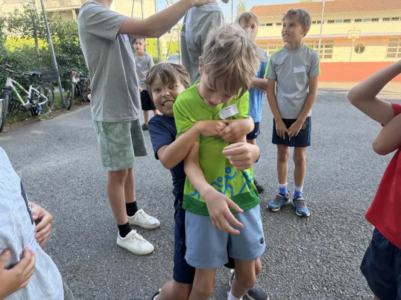 Kinder raufen spielerisch im Freien