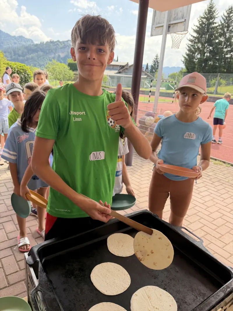 Kind backt Fladenbrote auf einer Grillplatte