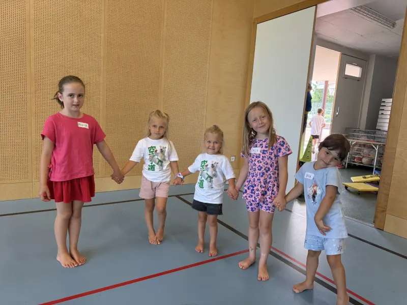 Fünf Kinder stehen händehaltend in einer Reihe