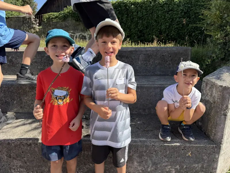 Kinder halten geröstete Marshmallows am Stock