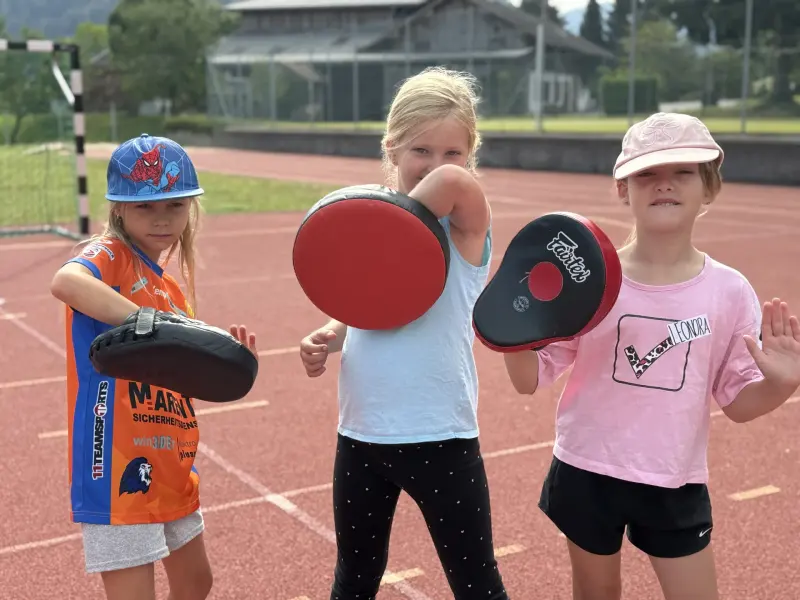 Kinder üben Schlagtechniken mit Pratzen im Freien