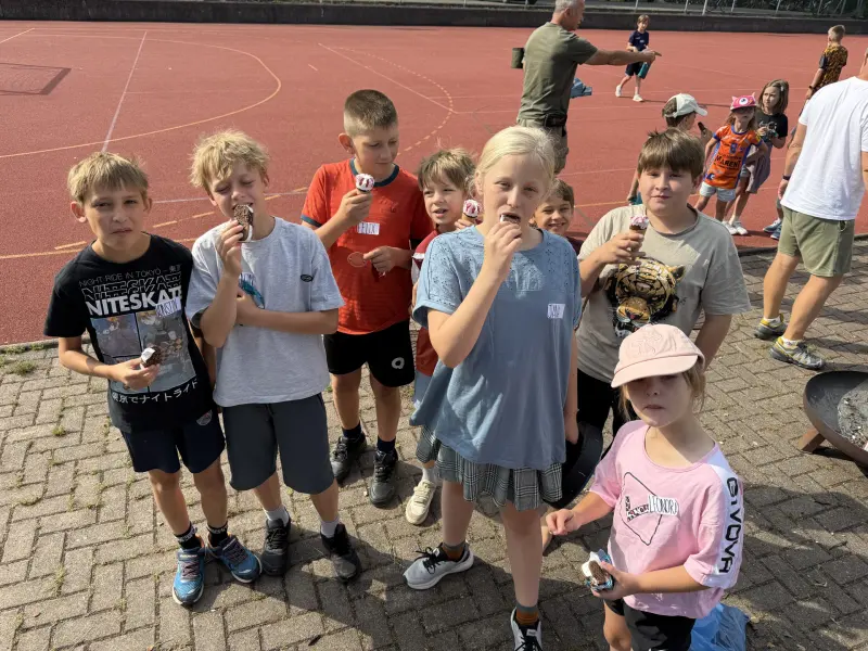 Gruppe von Kindern isst gemeinsam Eis im Freien