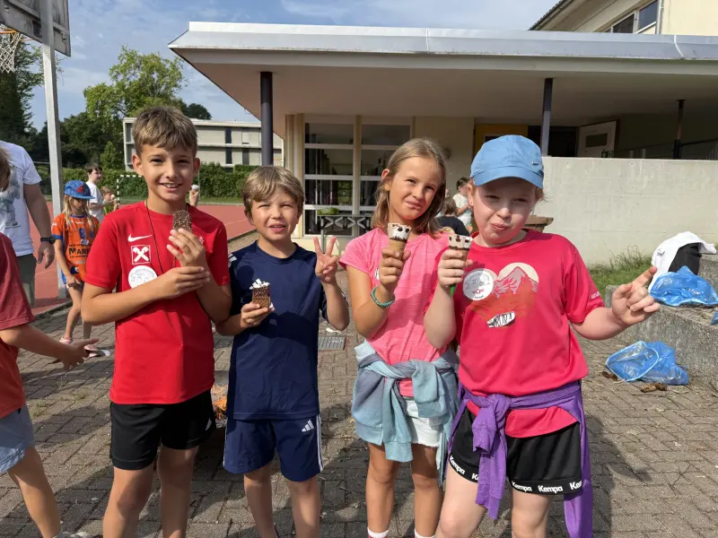 Kinder essen Eis am Stiel vor einem Gebäude
