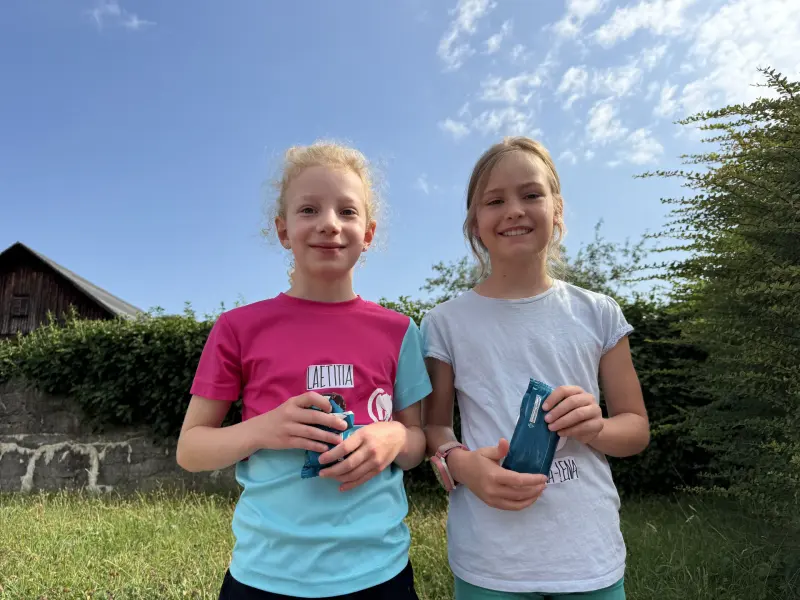 Zwei Kinder mit Eis am Stiel im Grünen