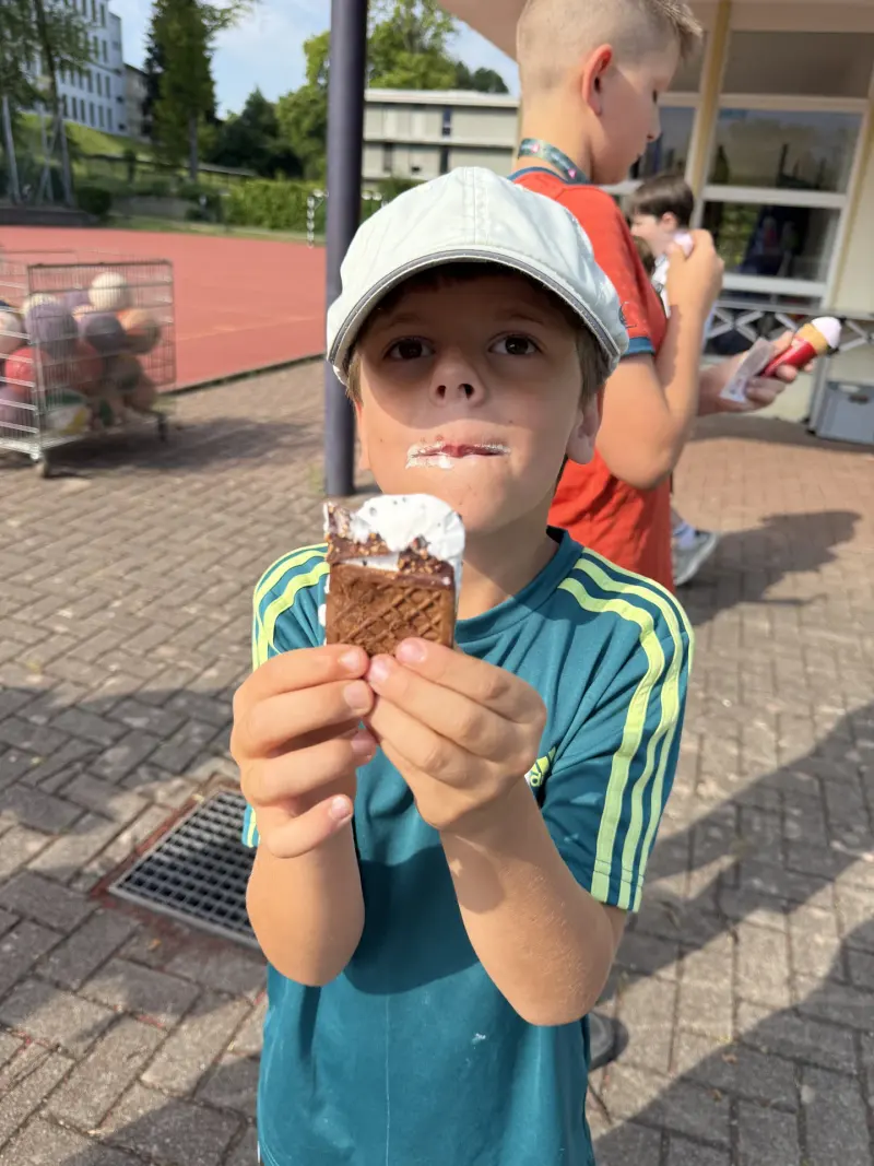 Kind hält angebissenes Eis in die Kamera